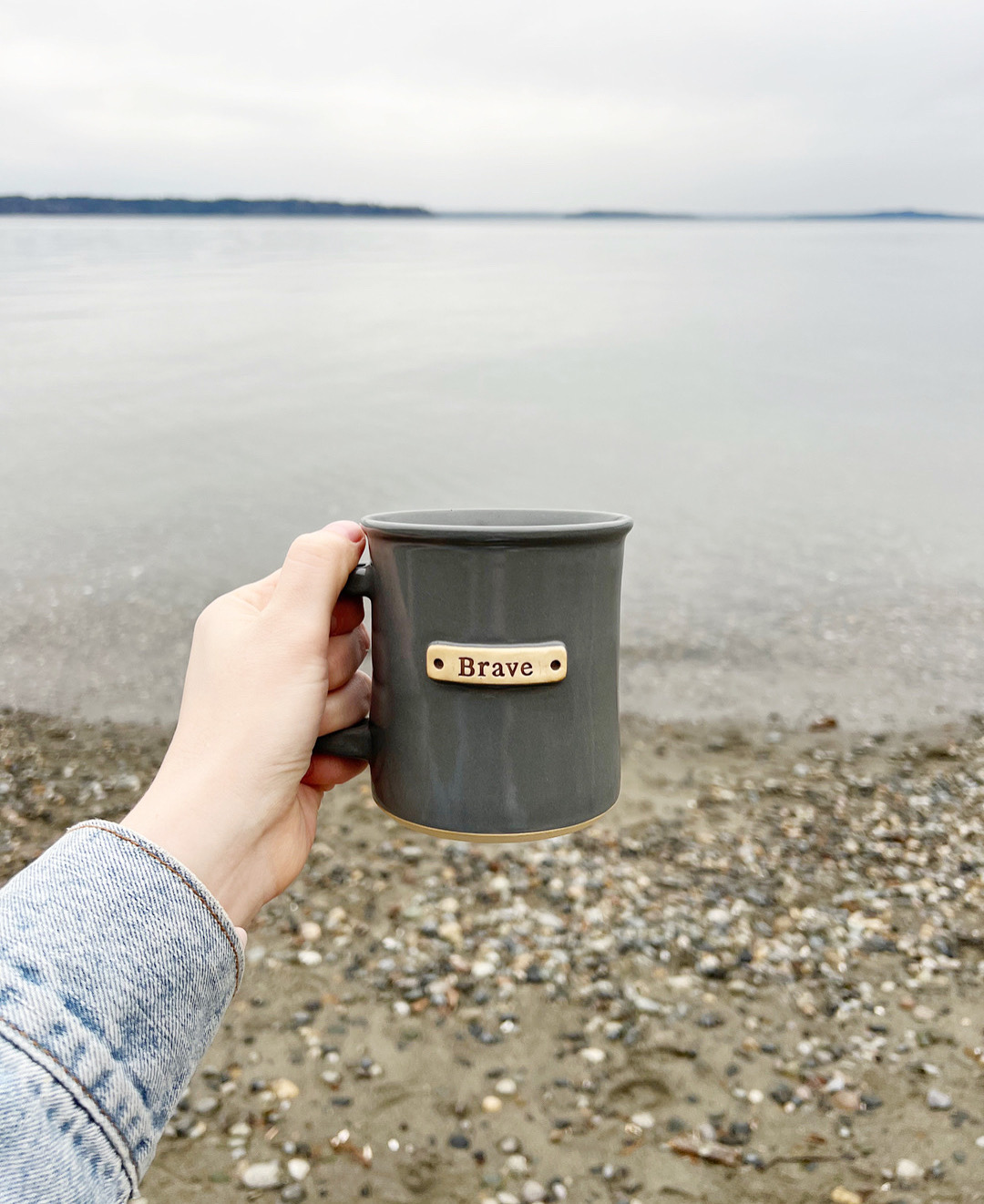 the word brave on a coffee mug in front of water in seattle, washington